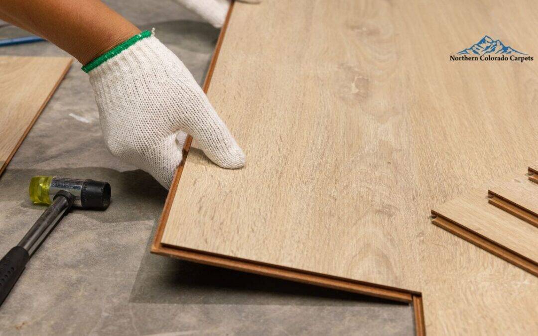 A team member from Northern Colorado Carpets installing hardwood flooring.